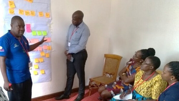 Two members of the Wakiso team present their problem tree to reviewers from Luwero