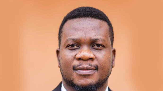 Head shot of an African man against a beige background