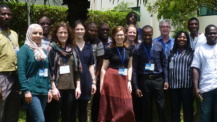 Outdoor group shot of standing, smiling Africa and European women and men