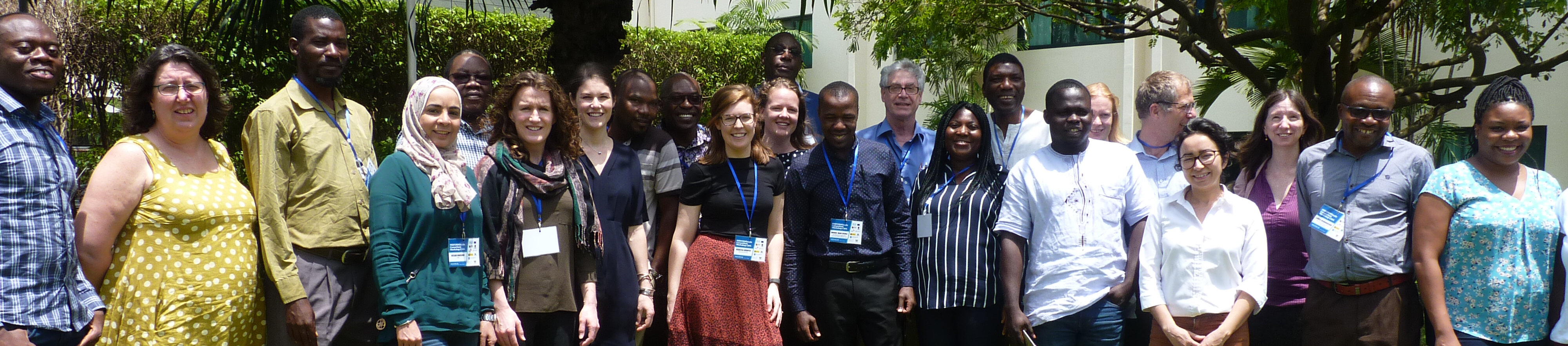The PERFORM2Scale team A line of standing, smiling men and women