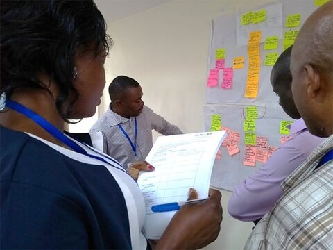 Members of the Nakaseke team use a checklist to review the strategies developed by the Wakiso team