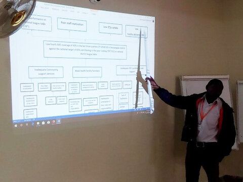 Standing man pointing to a diagram projected onto a wall